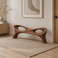 Long wood bench with a pinched middle and two oval openings in a Scandinavian entryway with white walls