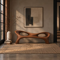 Long wood bench with a pinched middle and two oval openings in an industrial loft entryway with exposed brick