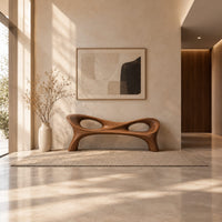 Long wood bench with a pinched middle and two oval openings in a bright open plan entryway