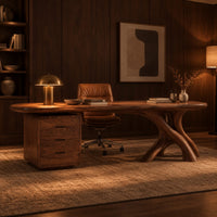 Desk with a long soft cornered top, three drawer block and branch leg in an evening home office with walnut wall paneling