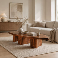 Leaf shaped coffee table with a pointed slab top on three chunky block legs in a Scandinavian living room with white walls
