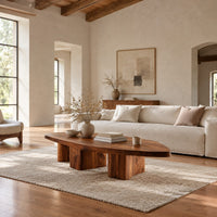 Leaf shaped coffee table with a pointed slab top on three chunky block legs in a bright open plan living room