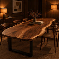 Long freeform wood table top with rippling live edge sides and warm grain in an evening dining room with walnut wall paneling