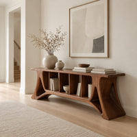Long console table with flared sculpted legs and a row of narrow open cubbies in a Scandinavian entryway with white walls