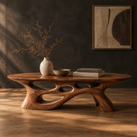 Long oval coffee table with a sweeping cutout base in a dark studio against a charcoal plaster wall