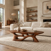 Long oval coffee table with a sweeping cutout base in a bright open plan living room