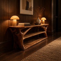 Long low shoe bench with open shelves and branching sculpted sides in an evening entryway with walnut wall paneling