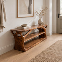 Long low shoe bench with open shelves and branching sculpted sides in a Scandinavian entryway with white walls