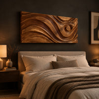 Long horizontal wall panel carved with sweeping waves and a raised disc above a bed in a dusk lit bedroom