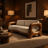 Sofa with a sculpted wood frame, open loop arms and a long seat cushion in an evening living room with walnut wall paneling