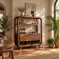 Bar cabinet with a looped wood frame, open shelf and slotted base in a bright dining room with arched windows and plants