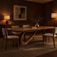 Dining table with a sweeping ribbon base that folds into an open loop in an evening dining room with walnut wall paneling