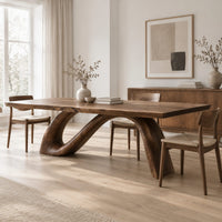 Dining table with a sweeping ribbon base that folds into an open loop in a Scandinavian dining room with white walls