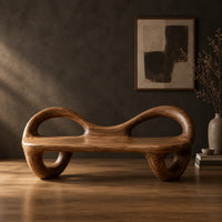 Bench with a flat plank seat, looped arms and ring shaped legs in a dark studio against a charcoal plaster wall