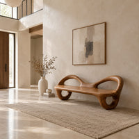 Bench with a flat plank seat, looped arms and ring shaped legs in a bright open plan entryway