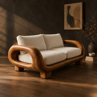 Sofa with thick looped wood arms, chunky block legs and cream cushions, three-quarter view showing the grain