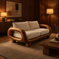 Sofa with thick looped wood arms, chunky block legs and cream cushions in an evening living room with walnut wall paneling