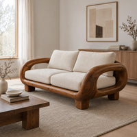 Sofa with thick looped wood arms, chunky block legs and cream cushions in a Scandinavian living room with white walls
