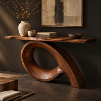 Corner detail of narrow console table with a live edge top on a sweeping looped base beside wood, brass and linen samples