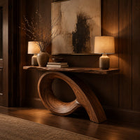 Narrow console table with a live edge top on a sweeping looped base in an evening entryway with walnut wall paneling