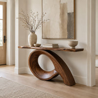 Narrow console table with a live edge top on a sweeping looped base in a Scandinavian entryway with white walls