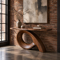 Narrow console table with a live edge top on a sweeping looped base in an industrial loft entryway with exposed brick