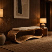 Wooden bench made from a looped ribbon frame with a slim cream cushion in an evening entryway with walnut wall paneling