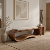 Wooden bench made from a looped ribbon frame with a slim cream cushion in a Scandinavian entryway with white walls