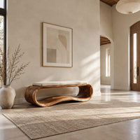 Wooden bench made from a looped ribbon frame with a slim cream cushion in a bright open plan entryway