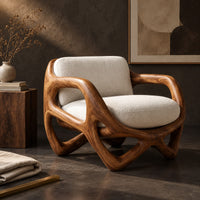Corner detail of armchair with a looped sculpted wood frame and a cushioned seat beside wood, brass and linen samples
