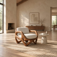 Armchair with a looped sculpted wood frame and a cushioned seat in a bright open plan living room