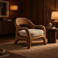 Accent chair with looping arms, an open scooped back and a soft seat cushion in an evening living room with walnut wall paneling