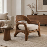 Accent chair with looping arms, an open scooped back and a soft seat cushion in a Scandinavian living room with white walls