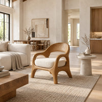 Accent chair with looping arms, an open scooped back and a soft seat cushion in a bright open plan living room