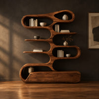 Tall bookshelf of stacked looping shelves on a solid base in a dark studio against a charcoal plaster wall