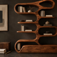 Corner detail of tall bookshelf of stacked looping shelves on a solid base beside wood, brass and linen samples