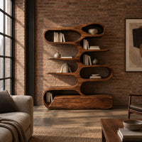 Tall bookshelf of stacked looping shelves on a solid base in an industrial loft living room with exposed brick