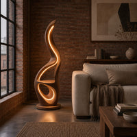 Flame shaped floor lamp with glowing loops and a small flat ledge in an industrial loft living room with exposed brick