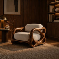 Armchair with looping carved wood arms and plush cream cushions in an evening living room with walnut wall paneling