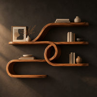 Looping ribbon wall shelves joined by a central spiral coil in a dark studio against a charcoal plaster wall