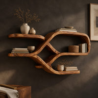 Corner detail of looping ribbon wall shelves with crossing wooden arms for books and bowls beside wood, brass and linen samples
