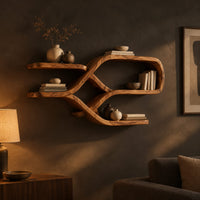 Looping ribbon wall shelves with crossing wooden arms for books and bowls in a dark living room at golden hour