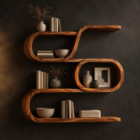 Looping wooden wall shelves with a middle oval cell and curled ends in a dark studio against a charcoal plaster wall