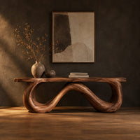 Bench with a flat slab seat on a looping wave shaped base in a dark studio against a charcoal plaster wall