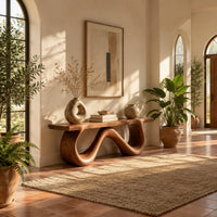 Bench with a flat slab seat on a looping wave shaped base in a bright entryway with arched windows and plants