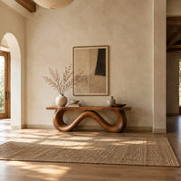 Bench with a flat slab seat on a looping wave shaped base in a bright open plan entryway