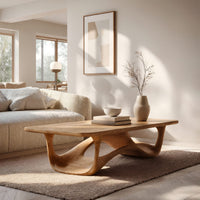 Looping wave base coffee table with pale top in an open plan space in daylight