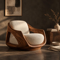 Corner detail of lounge chair with a sculpted wooden shell and cream seat cushion beside wood, brass and linen samples