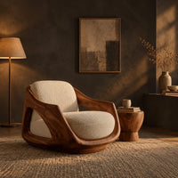 Lounge chair with a sculpted wooden shell and cream seat cushion in a dark living room at golden hour