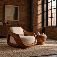 Lounge chair with a sculpted wooden shell and cream seat cushion in an industrial loft living room with exposed brick